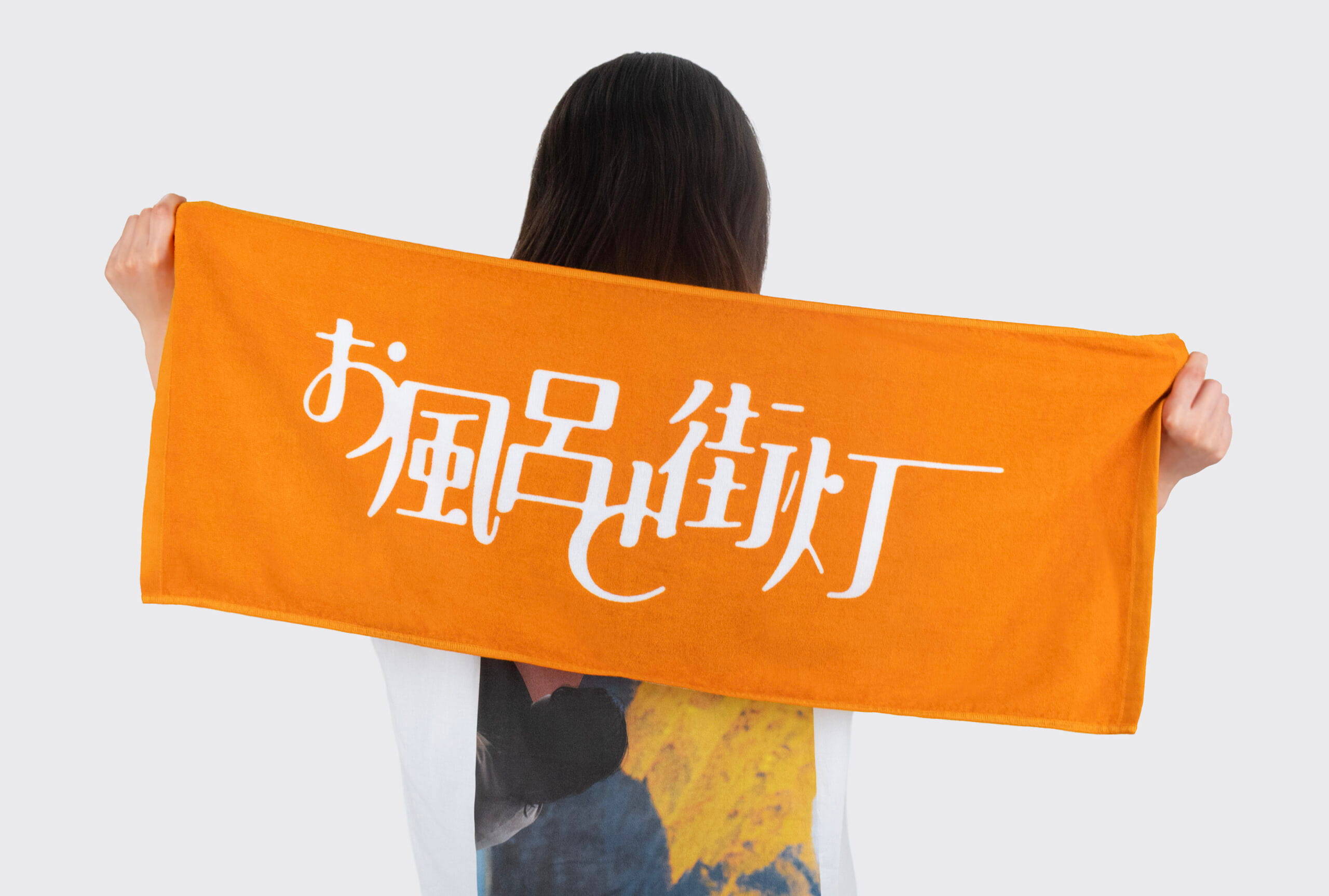 お風呂と街灯 ロゴタオルを持った女性